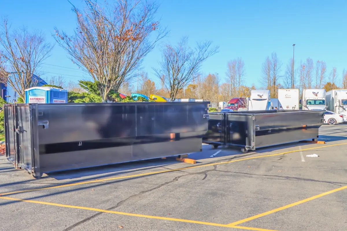 Professional dumpster rental service with roll-off container on residential driveway in Owosso